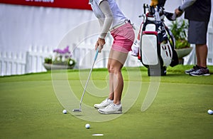 Golfer is pushing golf ball by golf club from tee boxes at golf course in competition game