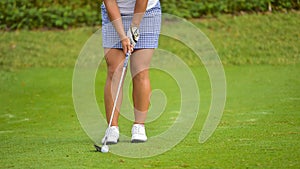 Golfer is pushing golf ball by golf club from tee boxes at golf course in competition game