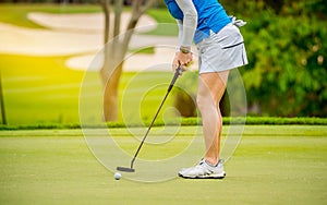 Golfer is pushing golf ball by golf club from tee boxes at golf course in competition game