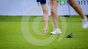 Golfer is pushing golf ball by golf club from tee boxes at golf course in competition game