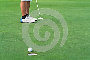 Golfer putt golf ball into hole on the green at golf course