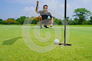 Golfer putt golf ball into hole on the green at golf course