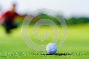 Golfer putt golf ball into hole on the green at golf course