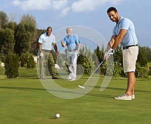 Golfer putting ball on green