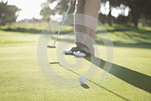 Golfer putting ball on the green