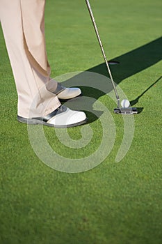 Golfer putting ball on the green