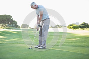 Golfer putting ball on the green