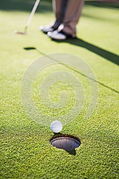 Golfer putting ball on the green