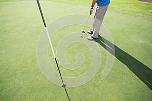 Golfer putting ball on the green