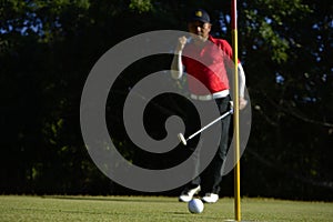 Golfer putting golf ball on the green golf, lens flare on sun set evening time