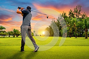 Golfer putting golf ball on the green golf, lens flare on sun set evening time, Golfer hitting golf shot with club on course