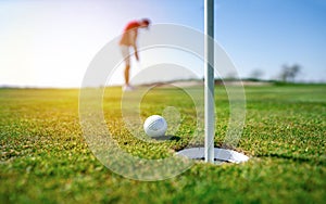 Golfer putting golf ball on the green golf.