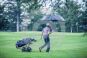 Golfer on a Rainy Day Leaving the Golf Course