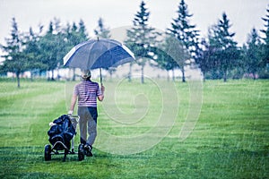 Golfer on a Rainy Day Leaving the Golf Course