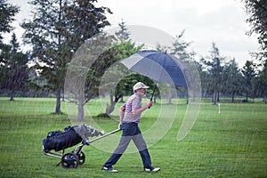 Golfer on a Rainy Day Leaving the Golf Course