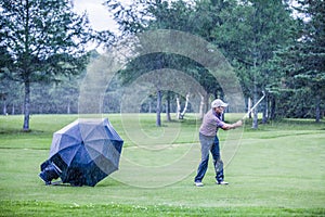 Golfer on a Rainy Day Swigning in the Fairway