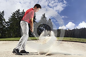 Golfer in sand trap.