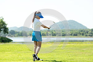 Golfer sport course golf ball fairway. People lifestyle woman relax after swing golf ball on the green.