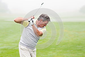 Golfer swinging his club on the course