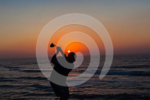 Golfer Swinging Sunrise Ocean