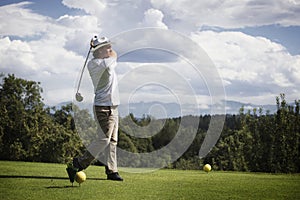 Golfer teeing off.