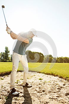 Golfer about to hit ball out of a sand bunker