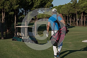 Golfer walking and carrying golf bag