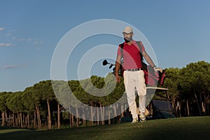 Golfer walking and carrying golf bag