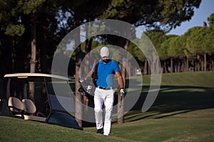 Golfer walking and carrying golf bag