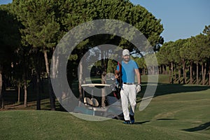 Golfer walking and carrying golf bag