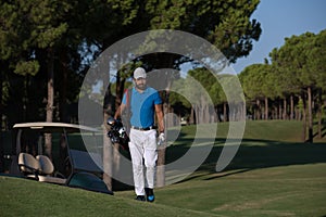 Golfer walking and carrying golf bag