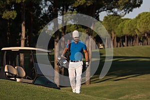 Golfer walking and carrying golf bag