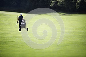 Golfer walking on fairway with bag. photo