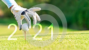 Golfer woman putting golf ball for Happy New Year 2021 on the green golf for new healthy.