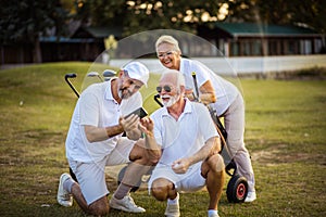 Golfers on court. Two men using smart phone