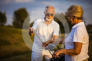 Golfers friends. Seniors golfers on the filed talking
