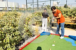 golfers with parents playing golf at sunny day