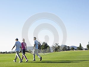 Golfers Walking On Golf Course