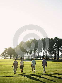 Golfers Walking On Golf Course