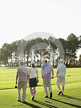 Golfers Walking On Golf Course