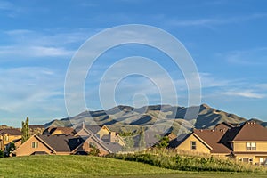 Golfing area overlooking a scenic view of houses and mountain against blue sky