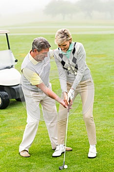 Golfing couple putting ball together