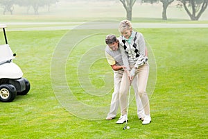 Golfing couple putting ball together