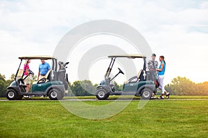 Golfing is fun for the whole family. two couples with golf carts spending a day on the golf course.