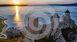 Golubac fortress castle walls standing on Danube river bank in  sunset rays aerial panorama, Serbia