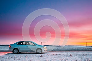 Volkswagen Polo Car Sedan Parking On A Roadside Of Country Road On A Background Of Dramatic Sunset Sky At Winter Season