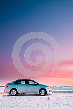 Volkswagen Polo Car Sedan Parking On A Roadside Of Country Road On A Background Of Dramatic Sunset Sky At Winter Season