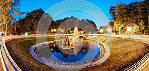 Gomel, Homiel, Belarus. Panorama Of Park Watercourse Channel Flowing Into River Through Stone Bridge In City Park In