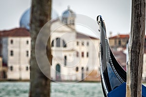 Gondola docked in Venice with wooden pylons in the foreground an