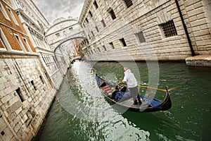 Gondola with gondolier and tourists on the canal